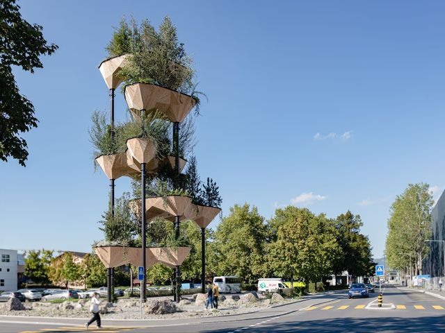 Timber planter pods stacked on slender columns above a street, planted with trees and shrubs